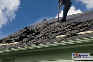 roofer sweeps off removed shingles for new replacement