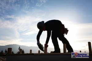 roofer caulks pipe on roof