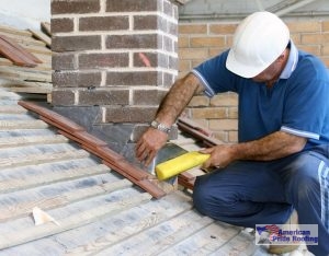 roofer caulks roof flashing