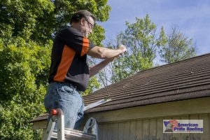 inspector taking evidence photo of damaged roof