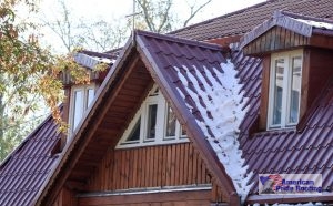 snow on sloped red metal roof